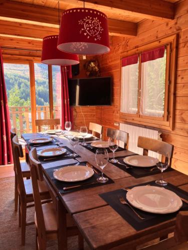 une grande table en bois avec des chaises et une salle à manger dans l'établissement Chalet Le Lauzet, à Les Deux Alpes