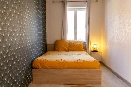 Le petit cocon في Levroux: غرفة نوم صغيرة مع سرير مع نافذة