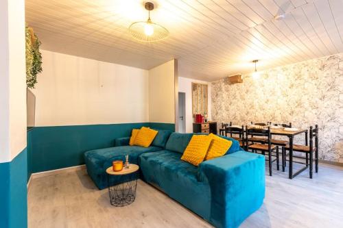 Le petit cocon في Levroux: غرفة معيشة مع أريكة زرقاء وطاولة