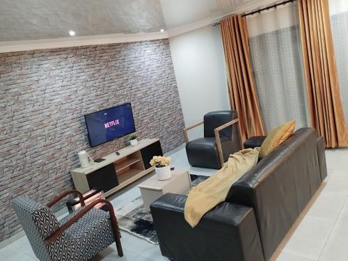 een woonkamer met een bank en een tv bij Tshepang Apartments Secunda in Secunda