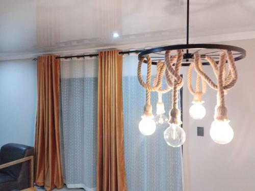 a chandelier with lights in front of a curtain at Tshepang Apartments Secunda in Secunda