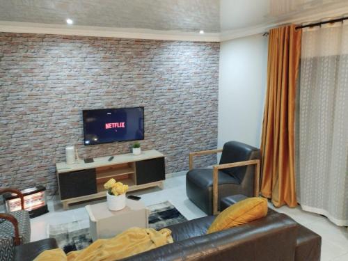a living room with a couch and a tv at Tshepang Apartments Secunda in Secunda