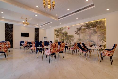 uma sala de jantar com mesas e cadeiras e um quadro em Comfort Inn Karnal em Tirāwari
