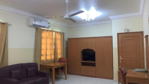 een woonkamer met een bank, een stoel en een kast bij Super OYO 151 Manam 2 Hotel Apartment in Muscat