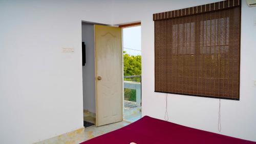 Habitación vacía con puerta y ventana en LAGUNA Guesthouse, en Chennai