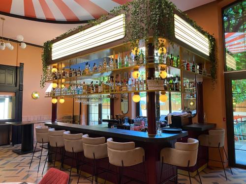 un bar en un restaurante con taburetes blancos en ClapClap Hôtel, Food & Bar, en Estrasburgo