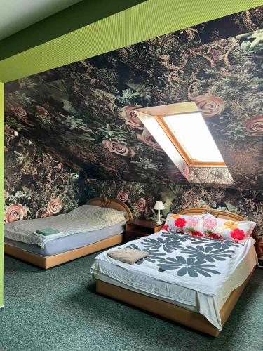 1 dormitorio con 2 camas y una pared con flores en Deizė en Tauragė