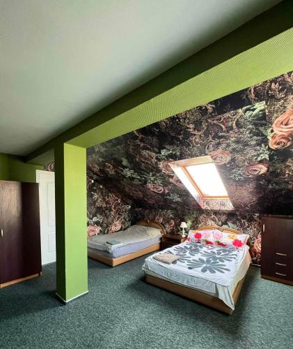 a bedroom with two beds and a wall with a mural at Deizė in Tauragė