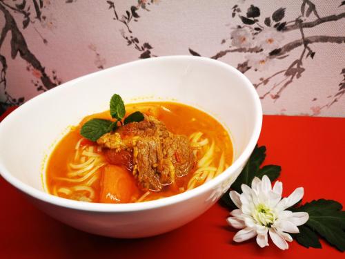 a bowl of soup on a red table at Minsu Hotel in Mülheim an der Ruhr