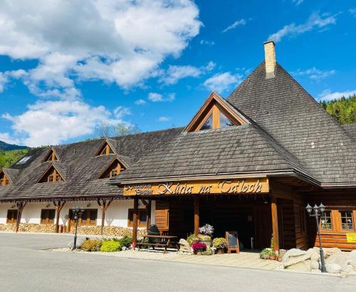 a log cabin building with a roof at Penzión & apartmány Kúria na Táľoch, Tále - Chopok JUH in Tale