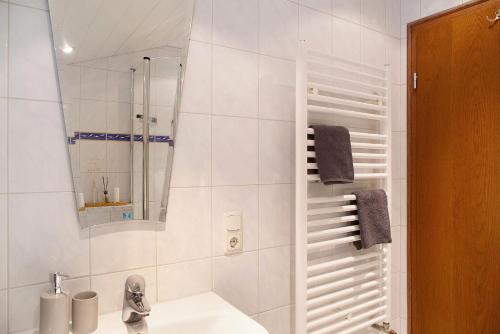 a bathroom with a sink and a shower with a mirror at Ferienwohnung Alpspitznest in Grainau