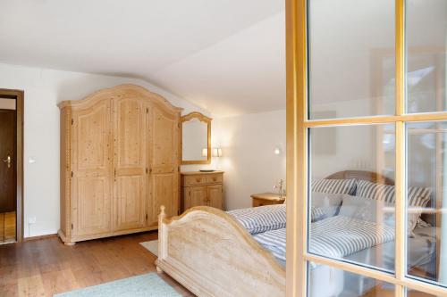 1 dormitorio con 1 cama y armario de madera en Ferienwohnung Alpspitznest, en Grainau