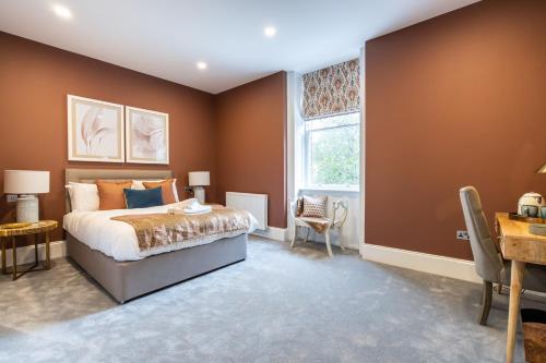a bedroom with a bed and a desk and a window at Old Abbey House in Abingdon