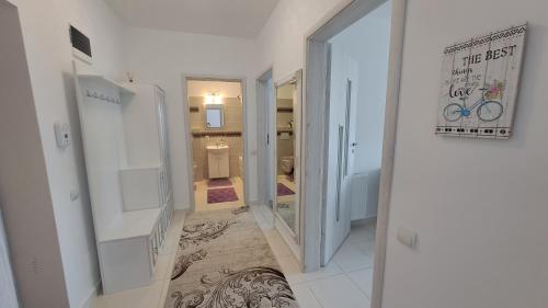 a hallway leading to a bathroom with a mirror at Apartament Ramonte in Zărneşti
