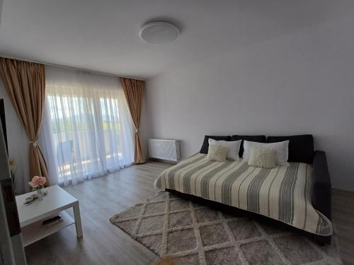a white room with a bed and a table at Apartament Ramonte in Zărneşti