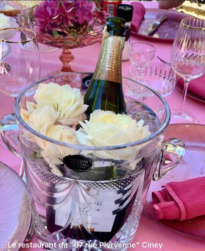 a bottle of champagne and flowers in a bucket on a table at Hôtel VCB Ciney Centre-ville in Ciney