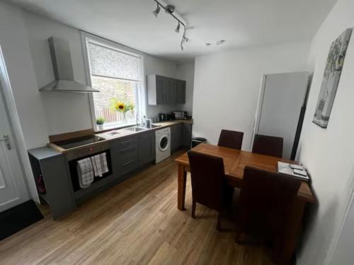 a kitchen and dining room with a table and chairs at 3 Bedroom House Brighouse in Brighouse