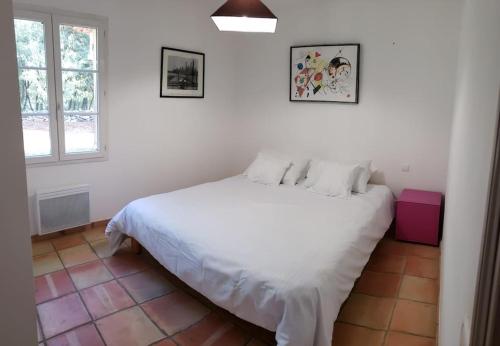 een witte slaapkamer met een wit bed en een raam bij Charmante Villa Ipsilon, jardin arboré provençal ! in Le Luc