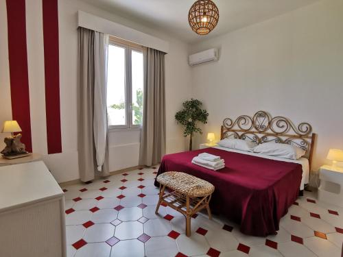 アレネッラにあるVilla Giardino Arenellaのベッドルーム1室(赤い毛布と椅子付きのベッド1台付)