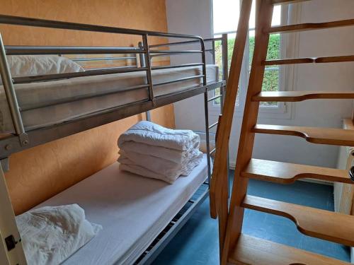 two bunk beds in a room with towels at Gîte Le Scoubidou, bord de mer in Saint-Jean-le-Thomas