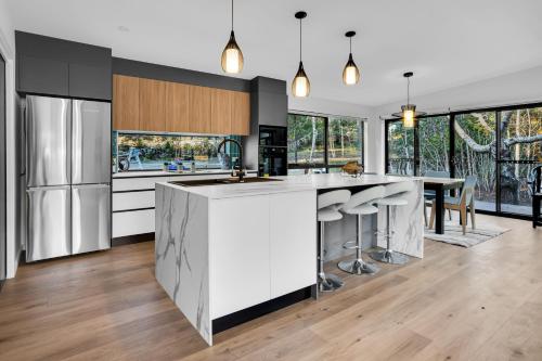an open kitchen with a large island with a counter top at Quamby Bluff Lake House, Deloraine, Tasmania in Golden Valley