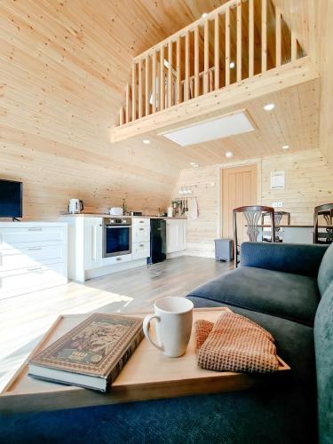 a living room with a couch with a coffee cup on a table at Bective Mill Glamping & Camping in Bective