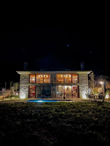 una gran casa de piedra por la noche en Modern Stone Villas with Swimming Pool en Aliveri
