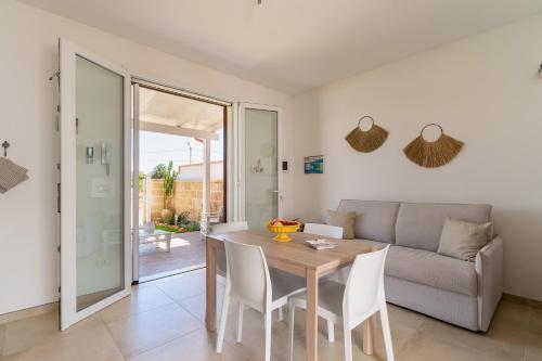 a living room with a table and a couch at Villino Summer by BarbarHouse in Torre Lapillo