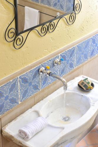 a bathroom sink with water running from a faucet at Albergo Diffuso Borgo Montemaggiore in Montemaggiore al Metauro
