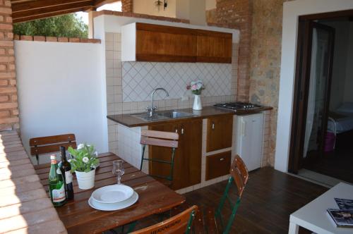 cocina con mesa de madera con fregadero y sidra de mesa en Villa Russo Casa Vacanze en Marina di Camerota