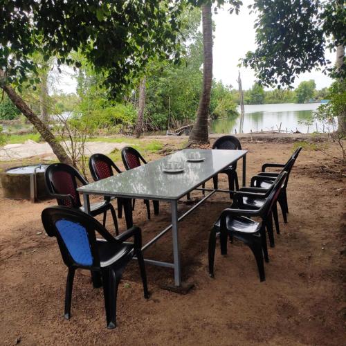 a group of chairs around a table in the dirt at Munroe Inn Homestay in Kollam