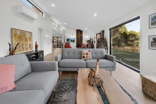 a living room with a couch and a table at Quamby Bluff Lake House, Deloraine, Tasmania in Golden Valley