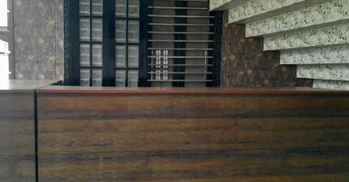 Habitación con estante de vinos y mesa de madera. en OYO Flagship Tirupati Lawn And Hotel, en Lucknow