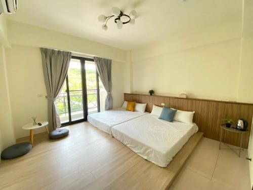ein Schlafzimmer mit einem Bett und einem großen Fenster in der Unterkunft 派森家Pi-thon In House in Yujing