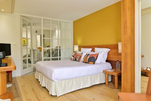 a bedroom with a large white bed and a television at Hôtel Pietracap in Bastia
