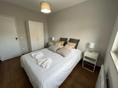 1 dormitorio con 1 cama grande con sábanas y almohadas blancas en Casa da Ti Bemvinda, 
