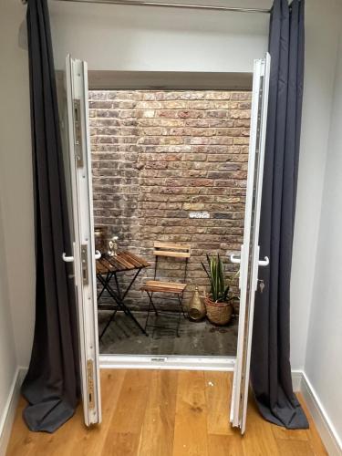 una porta aperta con un muro di mattoni dietro di Notting Hill Studio Room a Londra