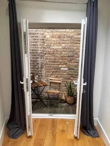 an open door with a brick wall behind it at Notting Hill Studio Room in London