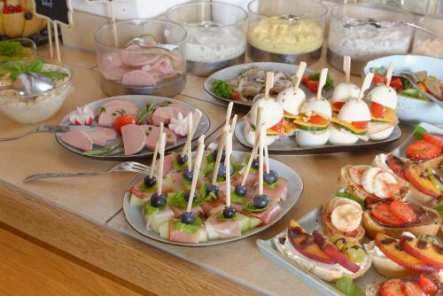 a buffet with plates of food on a table at Hotel ChiemseePanorama in Gstadt am Chiemsee
