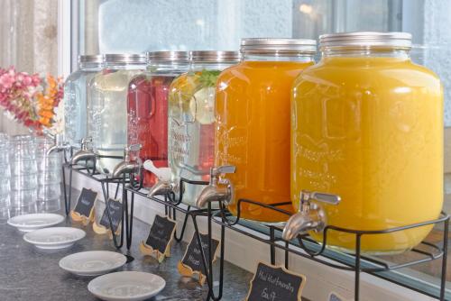 a group of four jars of orange juice on a shelf at Hotel ChiemseePanorama in Gstadt am Chiemsee