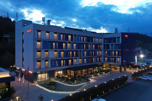 ein großes Gebäude mit Lichtern auf einem Parkplatz in der Unterkunft Hampton by Hilton Samsun in Samsun
