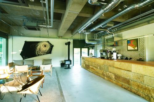 a room with a bar with chairs and a table at Auberge eaufeu in Komatsu