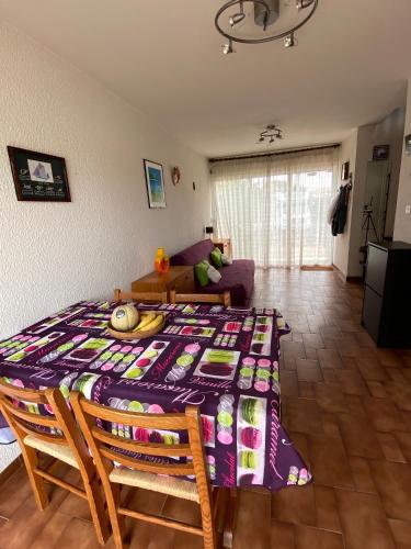 - un salon avec une table et une couverture violette dans l'établissement New this Year Oportoducap Villa in Cap Dagde, au Cap d'Agde