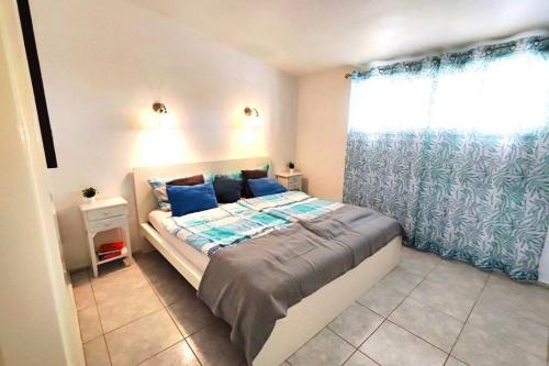 een slaapkamer met een bed met blauwe kussens en een raam bij Chalet Sonnen-Zeit in Chayofa