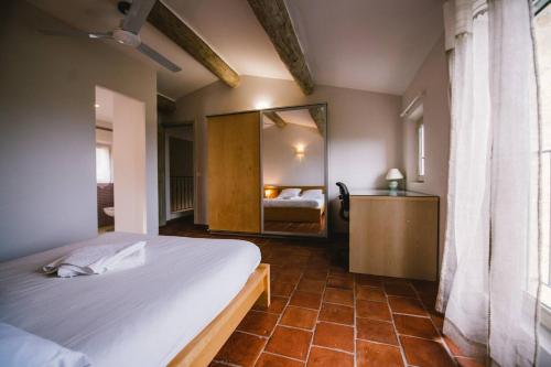 um quarto com uma cama grande e um espelho em Provencal stone farmhouse with sea view, swimming pool and spa em Tourrettes-sur-Loup