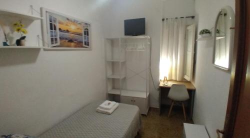 Habitación pequeña con cama y escritorio con ordenador. en Cozy single room Mercado Central, en Alicante
