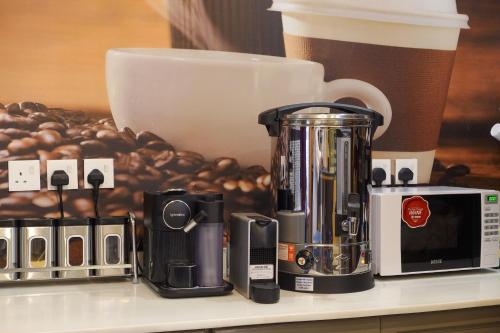 a coffee maker on a counter next to a cup of coffee at شقق سوات للشقق المخدومة 4 in Al Khobar