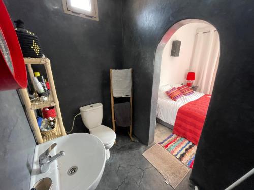 baño con lavabo, cama y espejo en La Maison de Mohamed en Wassane