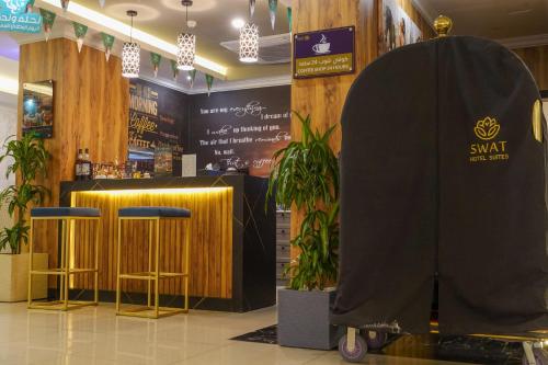 a restaurant with a table and two stools in a room at شقق سوات للشقق المخدومة 4 in Al Khobar