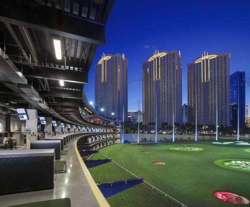 a golf course in a city with tall buildings at NO RESORT FEES-MGM Stripview-Jacuzzi-Formula 1 TRACK VIEW in Las Vegas